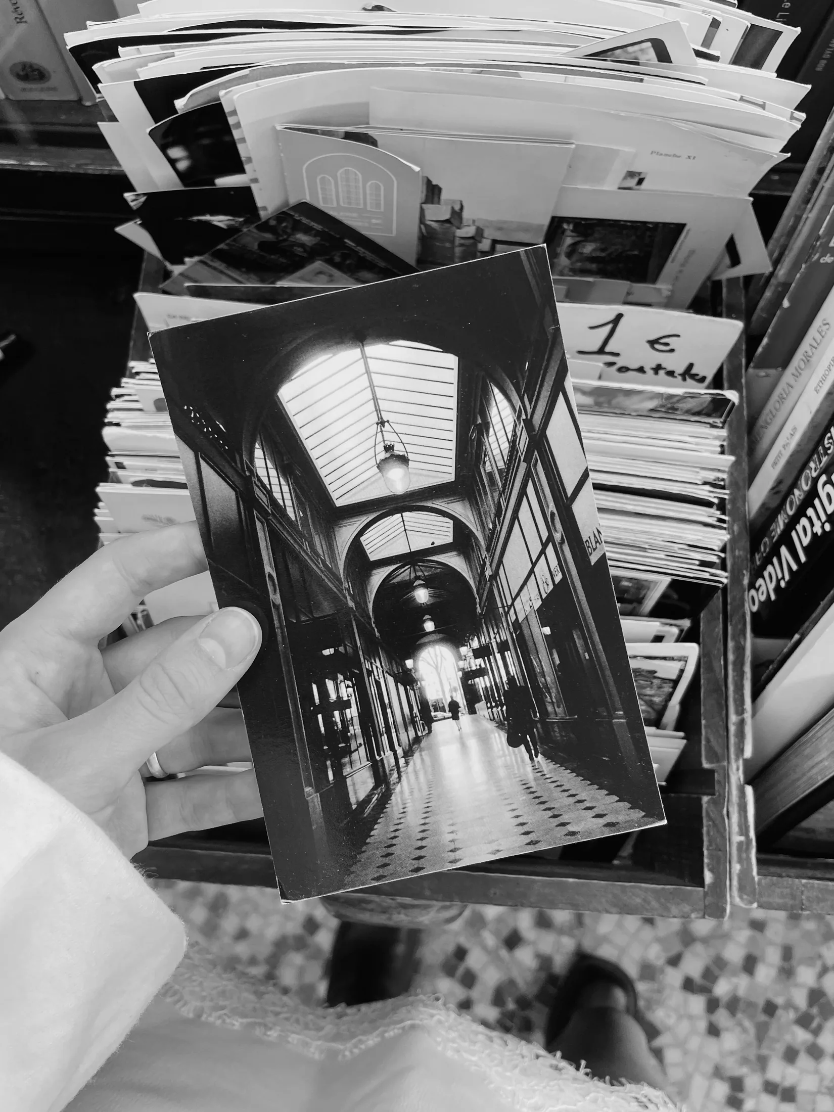A photograph held beneath the glass roof of a Parisian covered passage